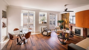 A spacious living area with a glass dining table, comfortable seating, a fireplace, and large windows offering a view of the city. - top luxury 3BR/3BA A/C art deco st honore architecturally designed (Paris)