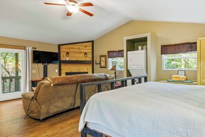 A bedroom with a bed, a sofa, a ceiling fan, a television, and a window with curtains. - Cherokee Ridge 7 - Pet Friendly Cottage All About Location, Location (Sautee Nacoochee)