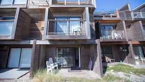 Un edificio moderno de varios pisos con balcones, ventanas amplias y zonas de estar al aire libre.