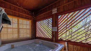 A wooden cabin with a hot tub, a window with blinds, and a sign indicating the cabin is a private place. - Couples Retreat - Romantic and Relaxing Cabin Retreat (Cleveland)