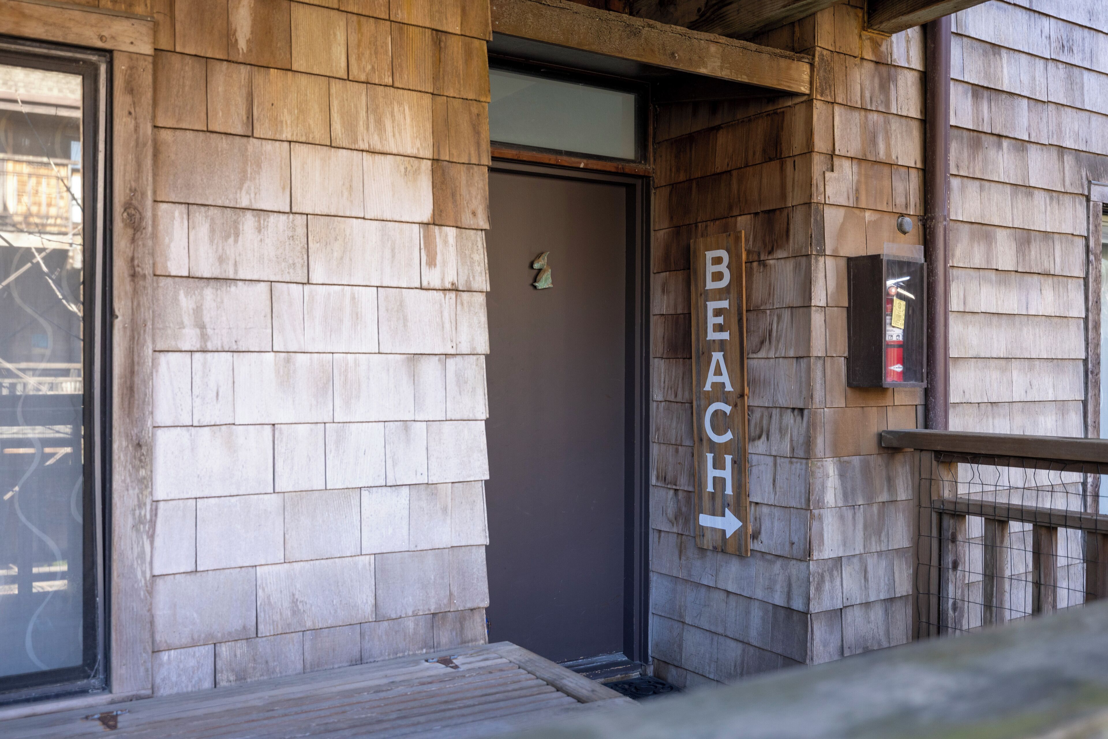 A wooden building with a sign indicating a beach direction.