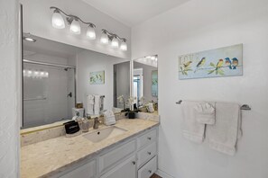 Een bad/douchecombinatie, een haardroger, handdoeken