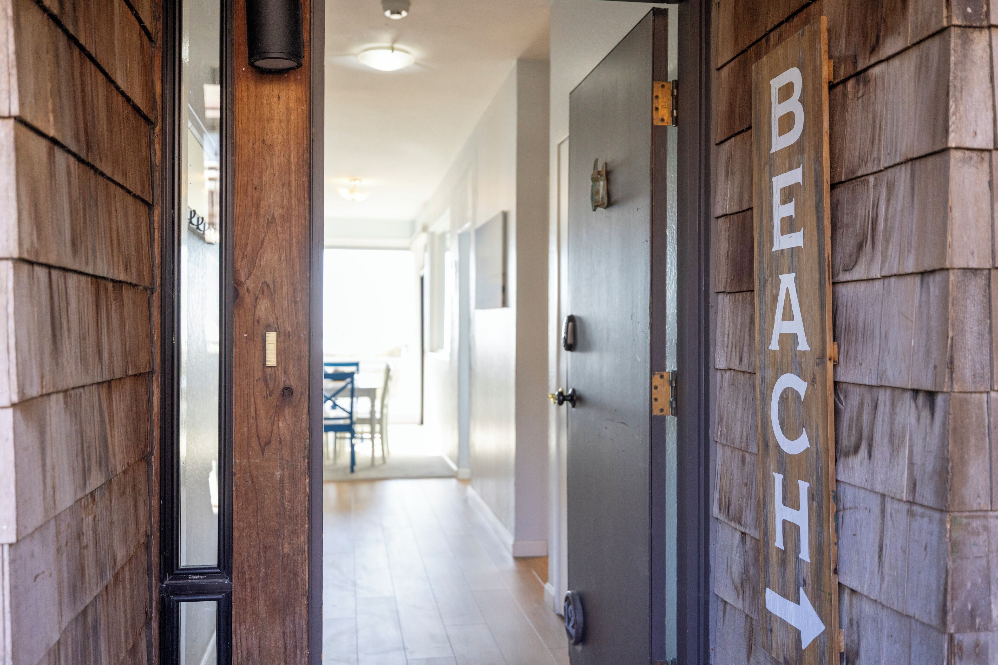 A hallway with wooden walls and a door labeled "BEACH" with an arrow pointing to the right.