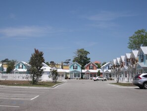 A row of colorful, single-story houses with a clear sky. - Hot Rental! Beach House-ONLY steps to the Ocean! Why stay at a hotel, book now!! (Myrtle Beach)