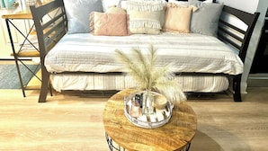 Une chambre à coucher comprenant un lit, une table de chevet, une lampe et des objets décoratifs.