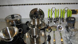 Een keuken met diverse roestvrijstalen pannen en keukengerei.