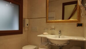 Een moderne badkamer met toilet, wastafel en spiegel.