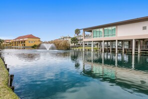 Un hôtel situé au bord de l’eau, doté d’une fontaine, d’une piscine et d’un bâtiment moderne aux grandes fenêtres.