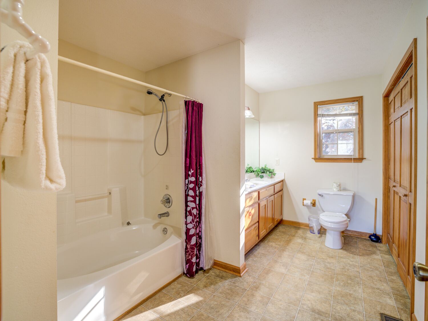 Un baño con bañera, inodoro y tocador.