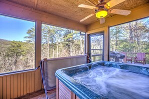 A hot tub in a wooden cabin with large windows overlooking a forest. - Hibernation Station - One Level Cabin Ideal for Family Vacations (Sautee Nacoochee)