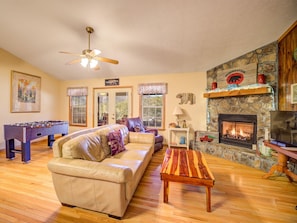 Cozy living room with a fireplace, foosball table, and comfortable sofa.