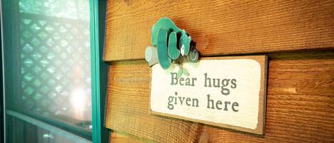 A wooden wall with a sign that reads "Bear hugs given here."