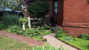 A brick building with a garden pathway leading to a door. - Vineyard Mansion - Carriage House - 1 Queen 1 Full Bed (St Joseph)