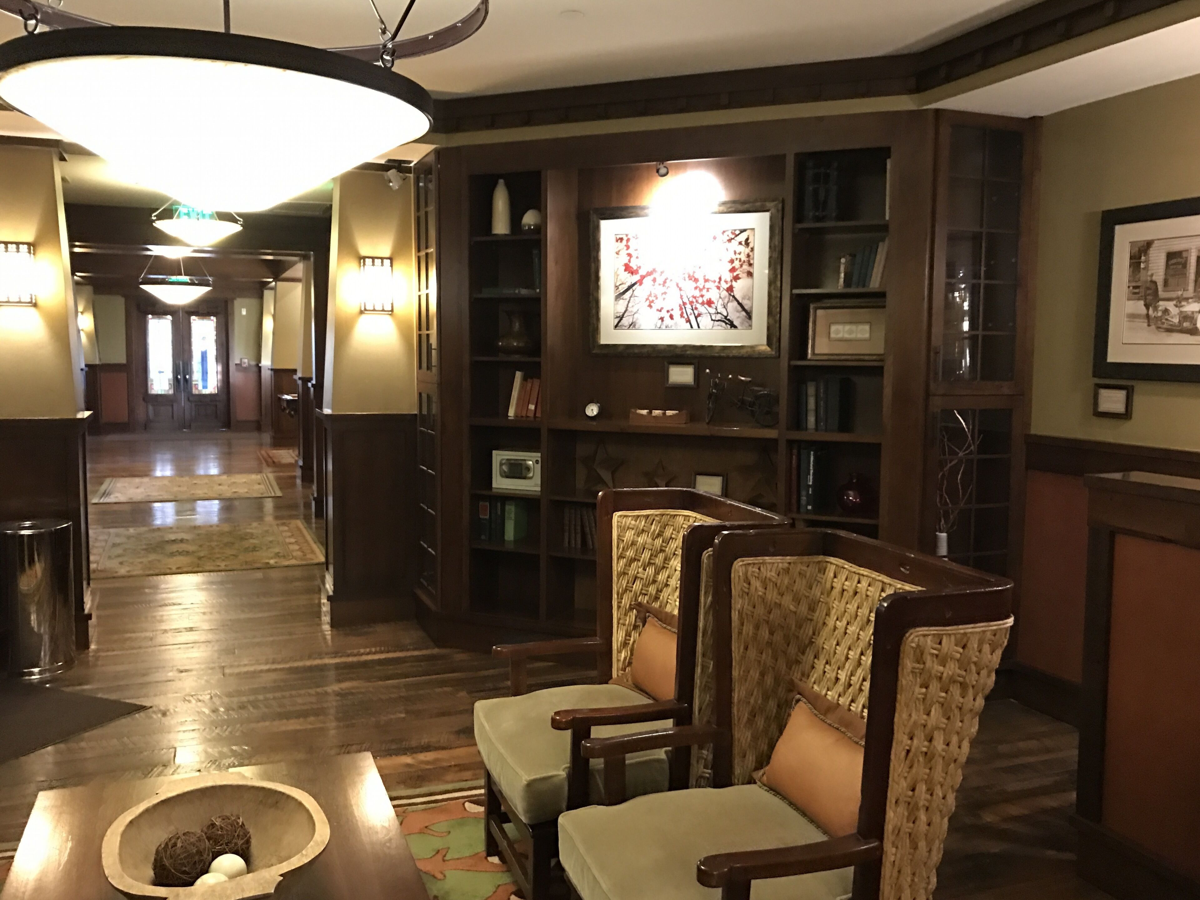 Um hall de entrada com balcão de recepção, área de estar e estante com quadros emoldurados.