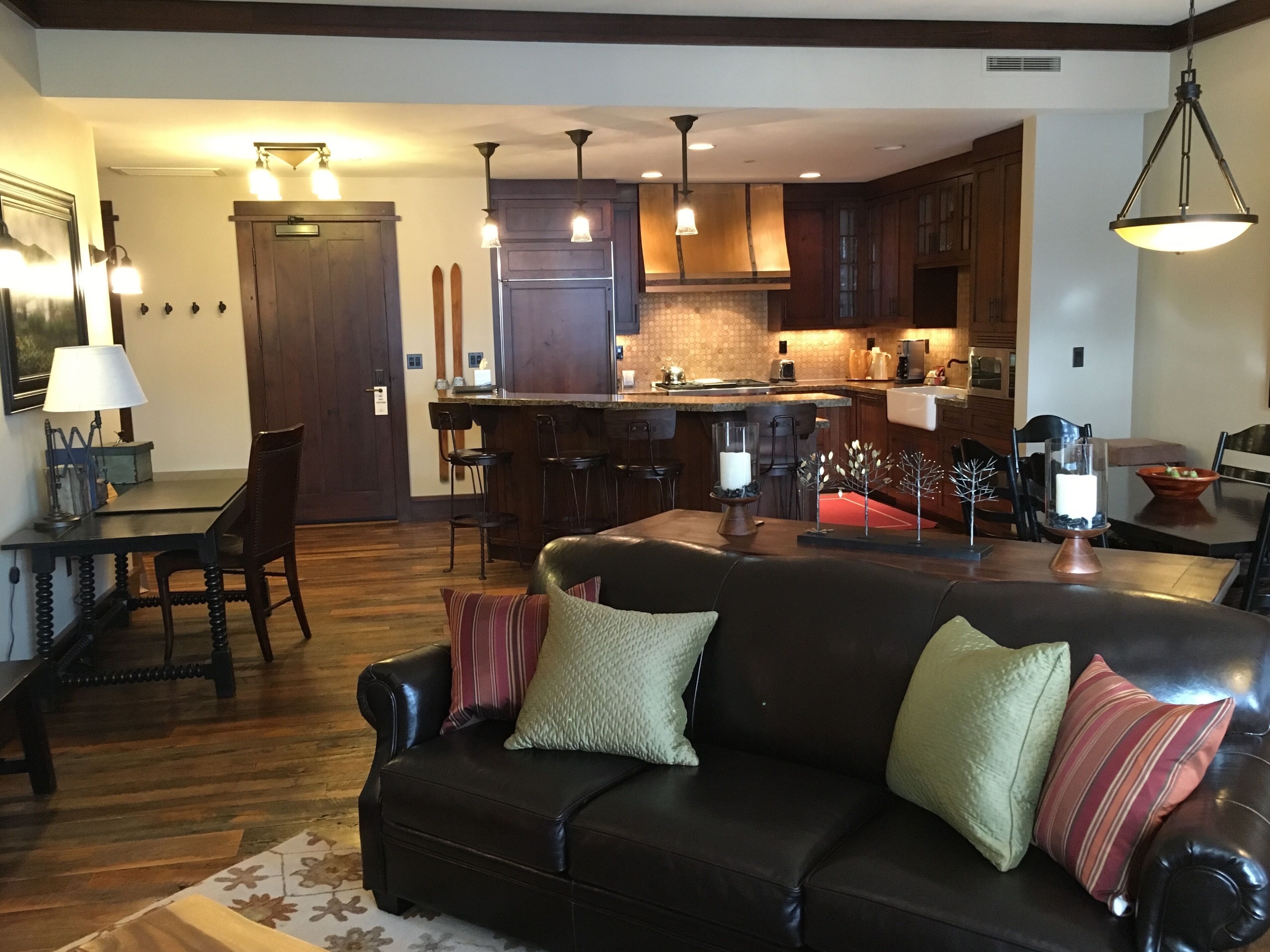 A modern kitchen with dark wood cabinets, a central island, and pendant lighting.