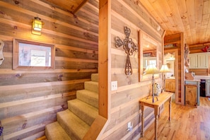 Staircase leads to an upper level with a framed picture and decorative metal piece.