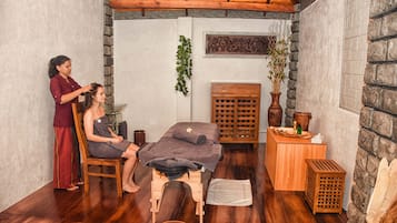 Relax in a serene spa room with a massage table, comfortable stool, and soothing ambiance.