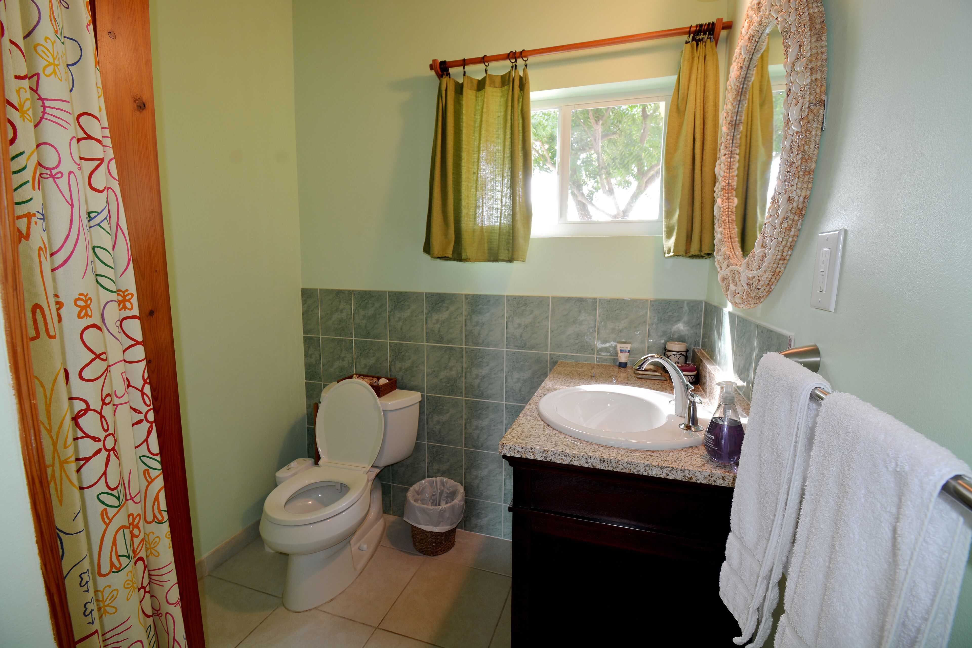 Ein Badezimmer mit Toilette, Waschbecken und Spiegel.