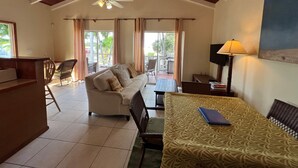 A spacious living area with a ceiling fan, a sofa, a dining table, and a view of the outdoors. - Exceptional ocean views, centrally located, just 1,700 ft off Grace Bay Beach (Providenciales)