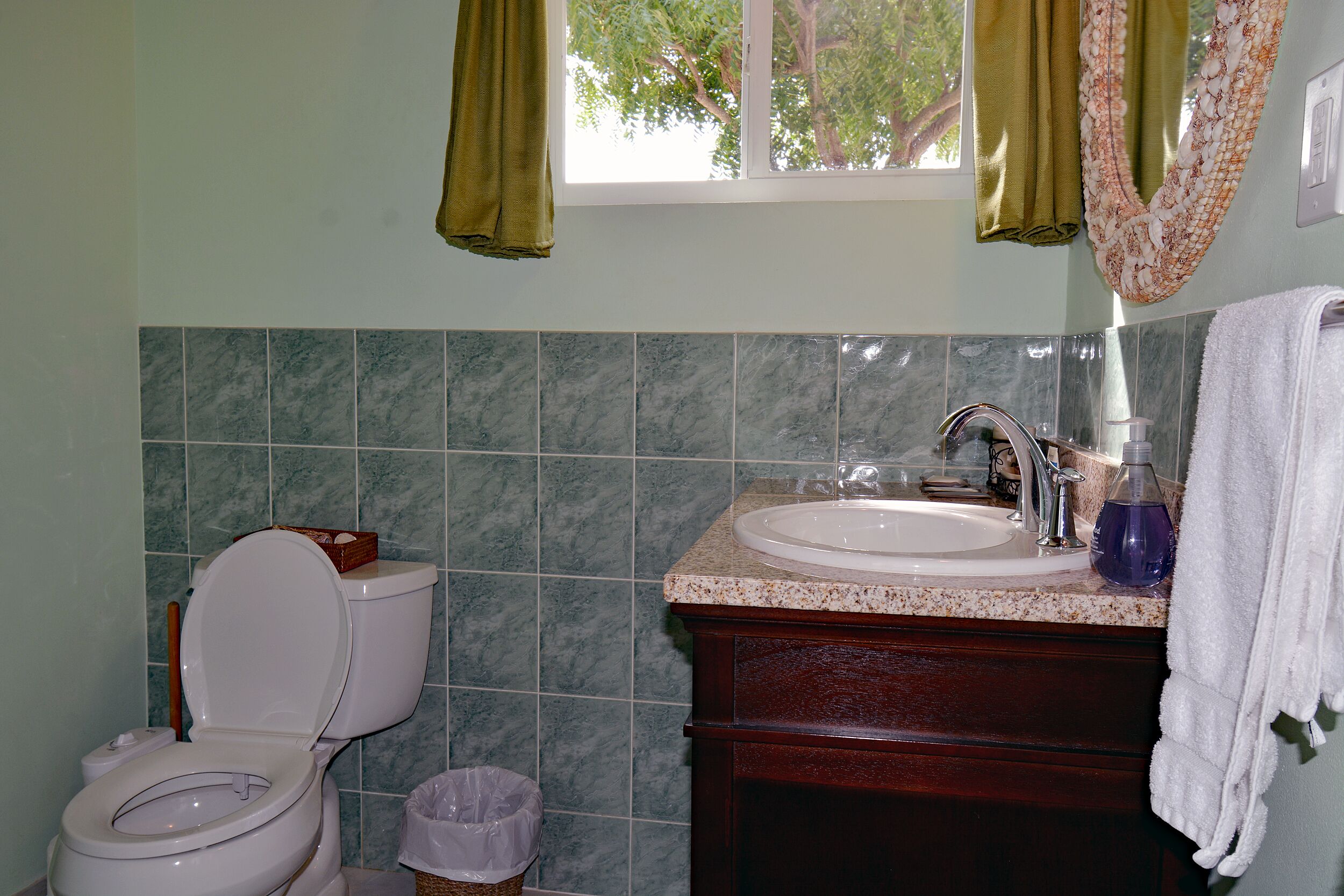 Ein Badezimmer mit Toilette, Waschbecken und Mülleimer.