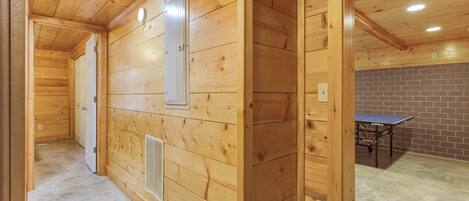 Un intérieur en bois avec une porte, une grille d’aération et une table de ping-pong.