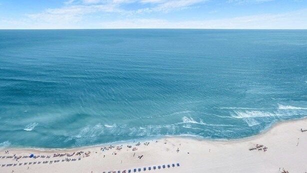 A beach with a clear view of the ocean and a sandy shore.
