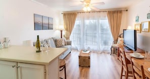 Relax in this stylish living room with a sofa set, dining area, and large windows.