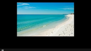 A beach with clear turquoise water and white sand.