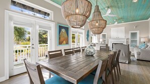 A spacious dining area with a wooden table, chairs, and a ceiling fan.