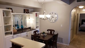 A kitchen with a dining table, chairs, a chandelier, and wall clocks. - Beautiful oasis of luxury in the desert of North Scottsdale, Arizona (Scottsdale)