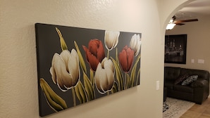 A living room with a large floral painting on the wall, a dark leather couch, and a patterned rug. - Beautiful oasis of luxury in the desert of North Scottsdale, Arizona (Scottsdale)