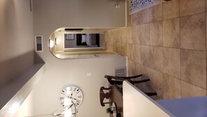 A narrow hallway with a ceiling fan, a clock, and a radiator. - Beautiful oasis of luxury in the desert of North Scottsdale, Arizona (Scottsdale)