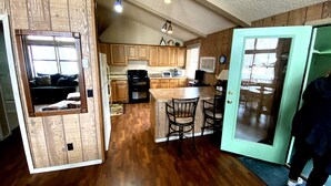 Una cocina compacta con armarios de madera, una isla central con sillas y un área de comedor.