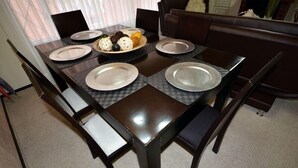 Une table à manger avec quatre assiettes, un bol de nourriture et deux chaises.