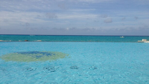 A clear view of a turquoise ocean with a sandy beach and a boat in the distance. - Beautiful, Spacious 3 Story, Waterfront Condo Bimini, Bahamas - Sleeps 10 (South Bimini)