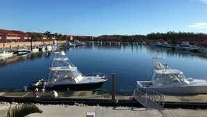 A marina with several boats docked, a wooden dock, and a row of buildings with red roofs in the background. - Beautiful, Spacious 3 Story, Waterfront Condo Bimini, Bahamas - Sleeps 10 (South Bimini)