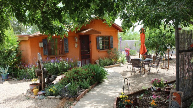 A rustic house with a garden path leading to a patio area with outdoor furniture. - HiddenOasisBandB   " A Bed & Breakfast Community" (Dragoon)