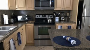 Kitchen features a stainless steel stove, oven, and sink with a faucet.
