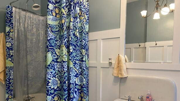 A bathroom with a bathtub, shower, and sink.