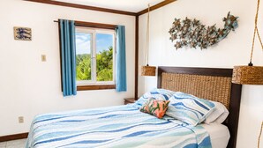 Una camera da letto con un letto, una finestra con tende, un lampadario a parete e un elemento decorativo a parete.