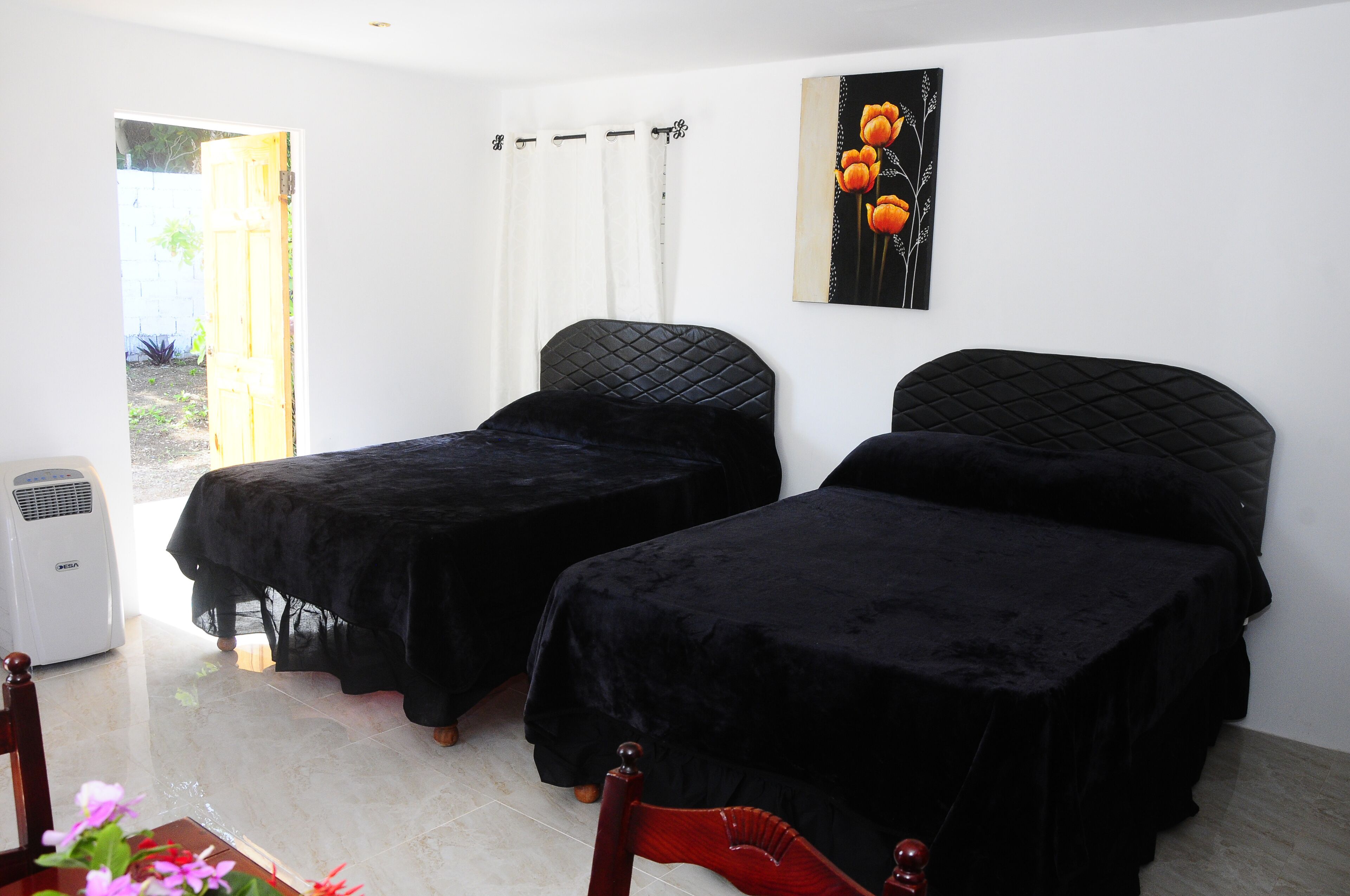 A room with two beds, a heater, and a window with curtains.
