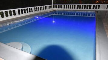 Una piscina con borde blanco y un único farol.