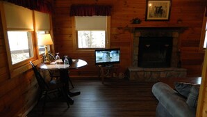 A cozy cabin interior with a dining area, a television, and a fireplace. - SAVE!  ROMATIC  GATLINBURG   GETAWAY!!    (Gatlinburg)