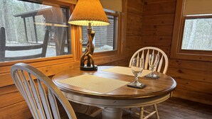 A wooden dining table with two chairs, a lamp, and a view of a snowy outdoor area. - SAVE!  ROMATIC  GATLINBURG   GETAWAY!!    (Gatlinburg)