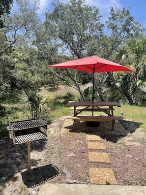Enjoy a serene outdoor picnic amidst lush surroundings and a convenient grill.