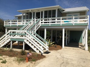 Enjoy the ocean views from the covered upper deck, accessible via a prominent staircase.