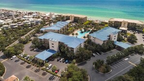 A resort with multiple buildings, a swimming pool, and a beach view. - Pool Front at High Pointe Resort-Ground Floor Unit (Panama City Beach)