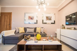 Relax in this stylish living room with a sofa, coffee table, sideboard, and flat-screen TV.