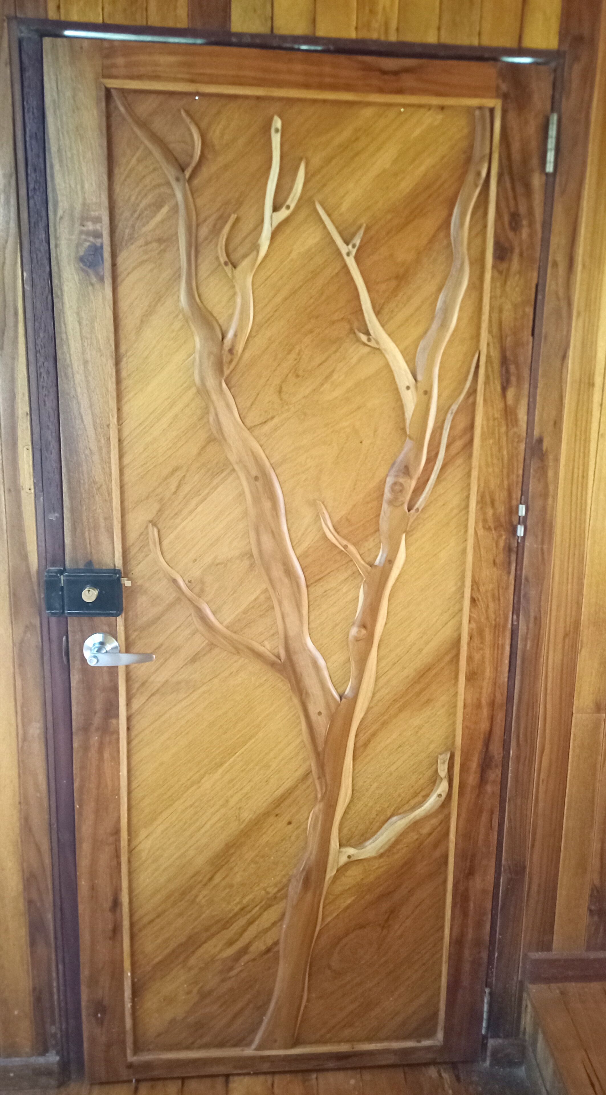 A wooden door with a carved tree design.