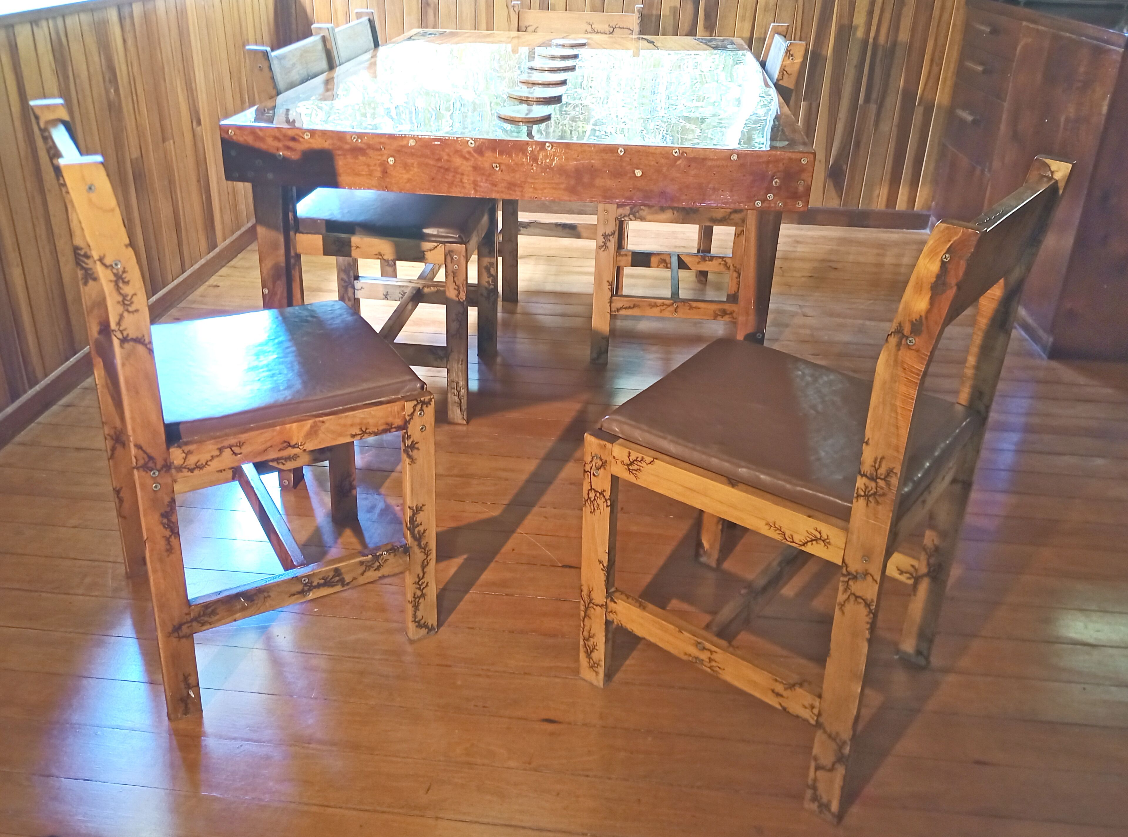 Una mesa de madera para comer con seis sillas, cada una con asiento y respaldo acolchados.